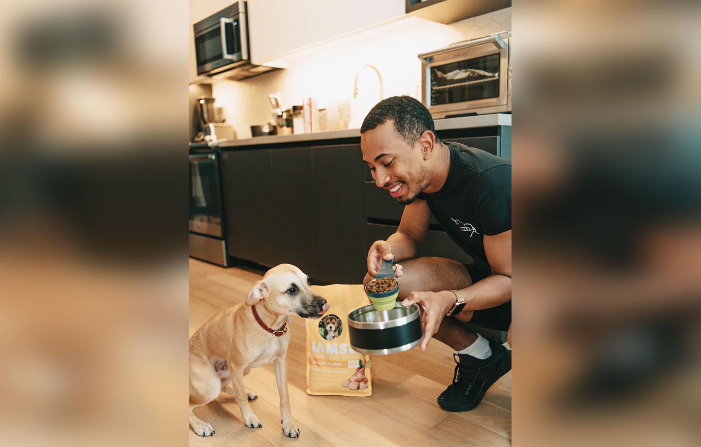 Kalen Allen feeding his dog Karter IAMS dog food