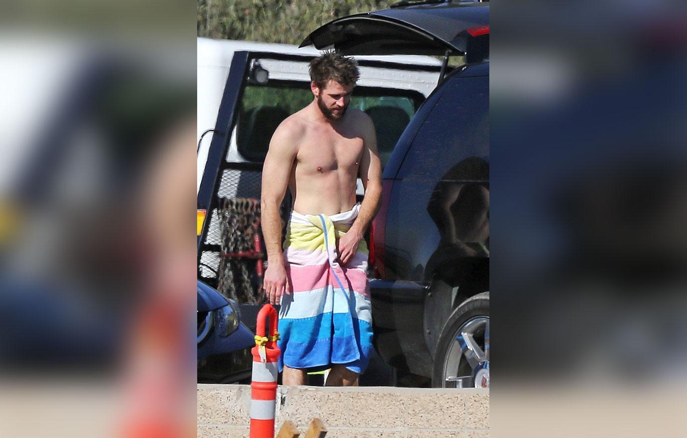 *EXCLUSIVE* Liam Hemsworth makes an adjustment after a day of surfing