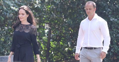 Angelina Jolie is all smiles as she steps out in Cambodia with a handsome mystery man, who has also been bonding with her six young children and buying her jewelry.