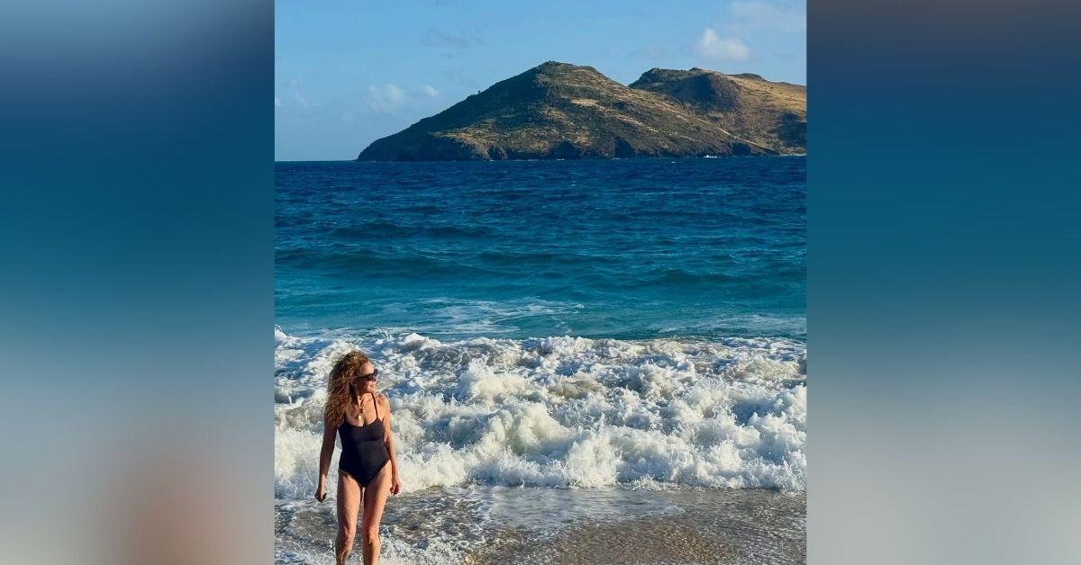 image of The star wore a black one-piece swimsuit and sunglasses during her beach day. 