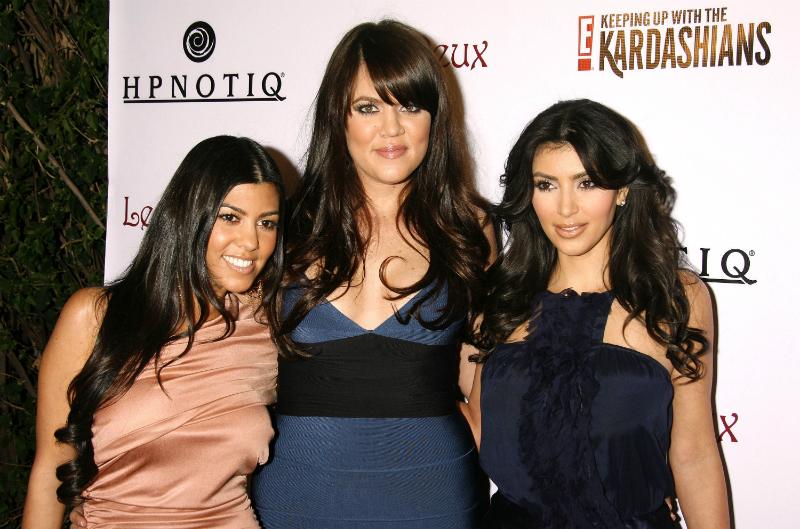 Kim Kardashian wears a midnight blue dress alongside sisters Kourtney and Khloe at the season 2 launch party for Keeping Up With the Kardashians in 2008.