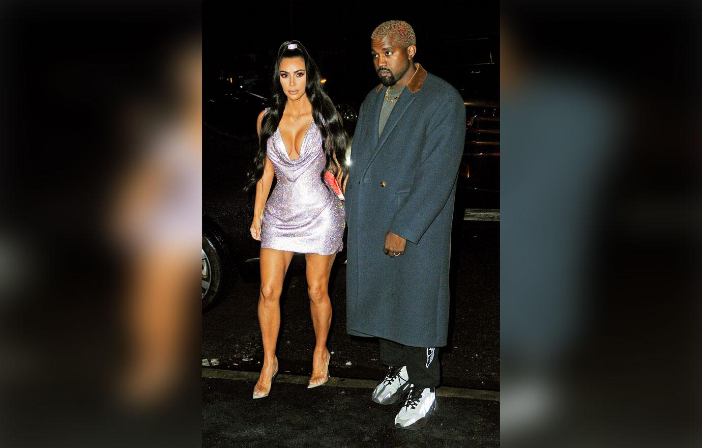 Kim Kardashian and Kanye West hold hands as they arrive to the Versace Fashion Show