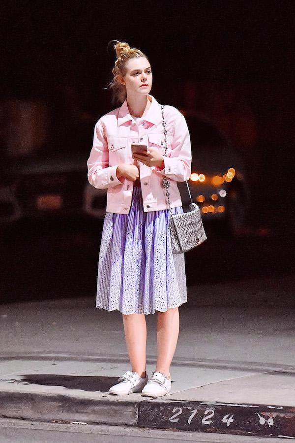 EXCLUSIVE: Elle Fanning sits on a curb and chats with a friend after dinner at Little Dom&#8217;s in Los Feliz, CA.