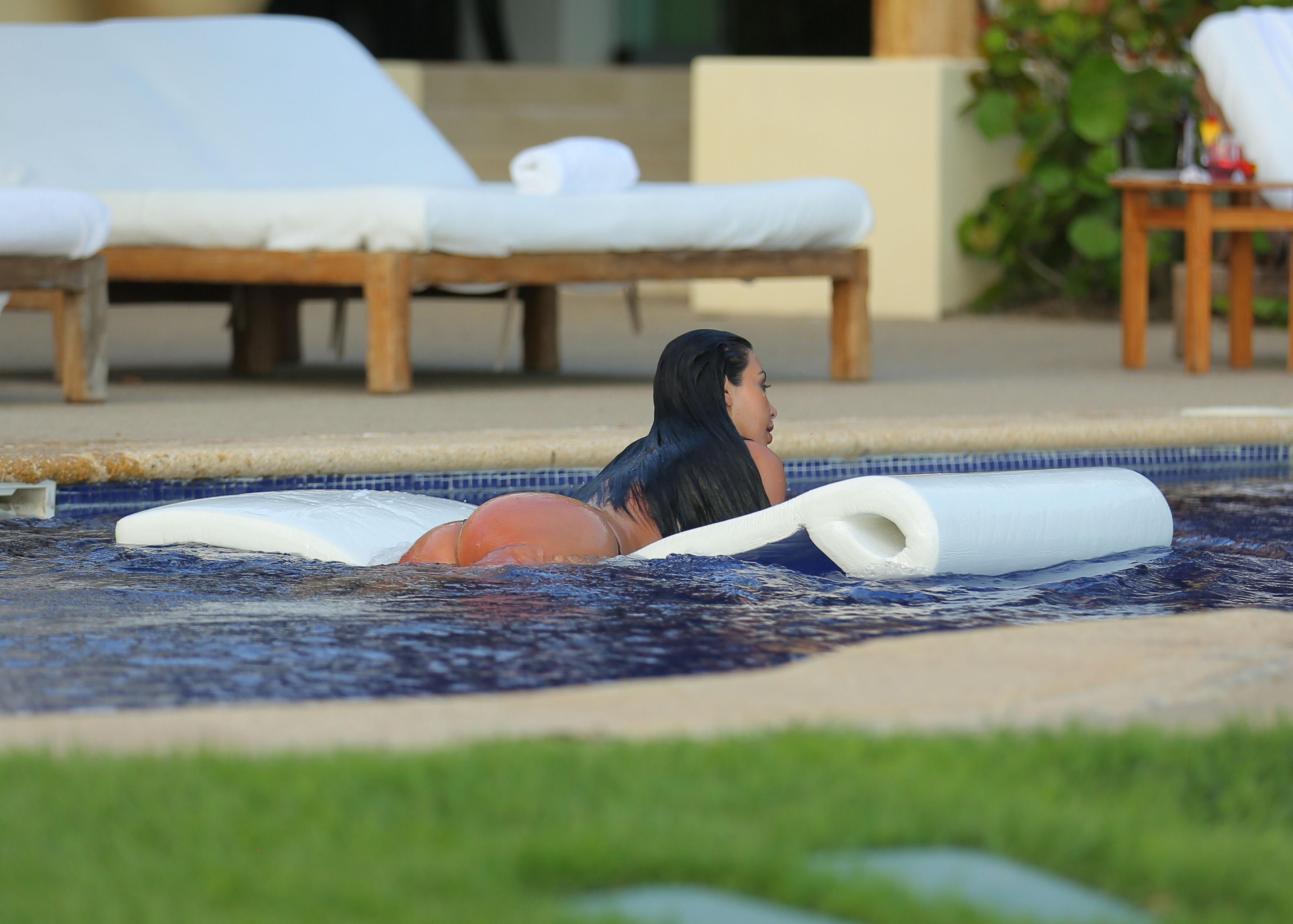 EXCLUSIVE: ** PREMIUM RATES APPLY ** NO WEB USAGE ** Kim Kardashian, wearing a skimpy black bikini, takes a plunge in the pool as she enjoys a second honeymoon in Mexico with Kanye West