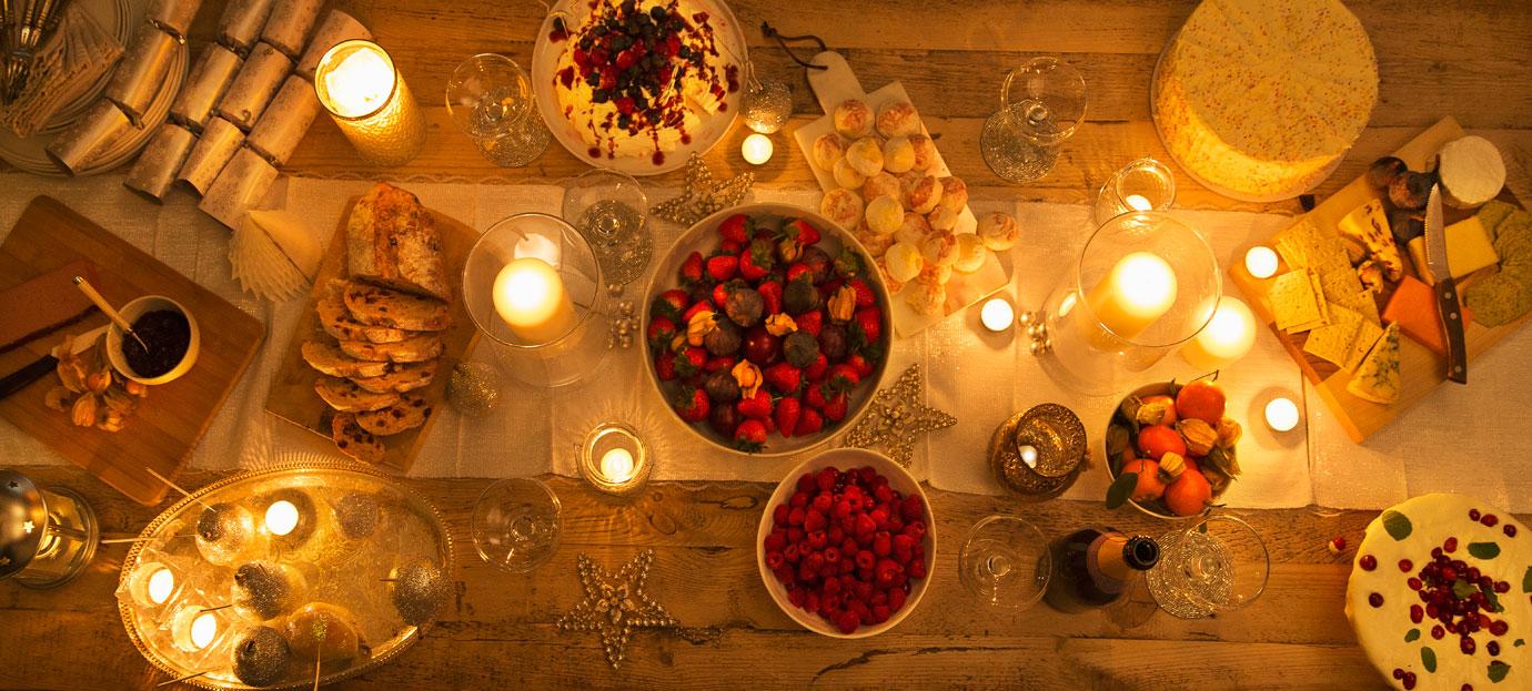 Overhead view candlelight table with Christmas desserts