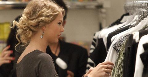 Taylor Swift looking though a rack of clothes.