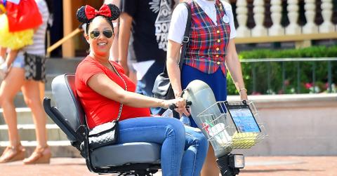 EXCLUSIVE: Pregnant Tamera Mowry rides a scooter at disneyland as she enjoys the day with her family