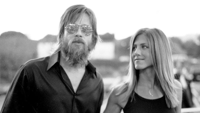 black and white photo of men with beard and woman staring up at him