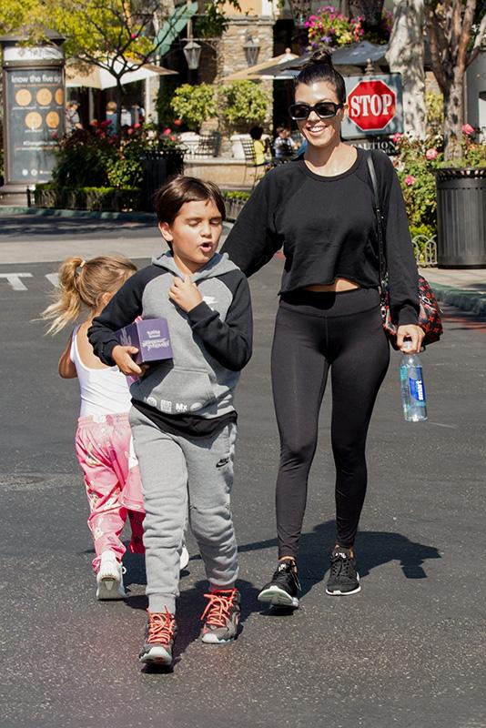 Kourtney Kardashian takes her kids to the movies while Scott Disick lives it up in London