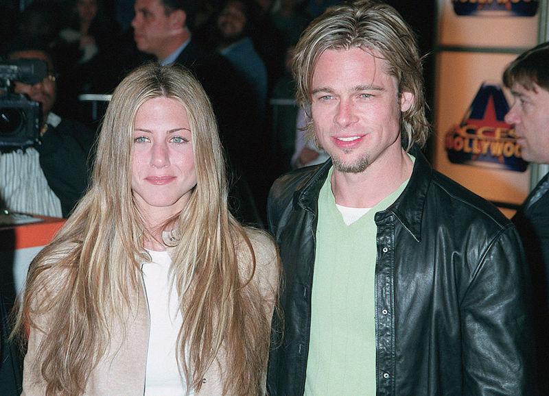 Light brown haired woman and man with long hair in leather jacket smiling at event