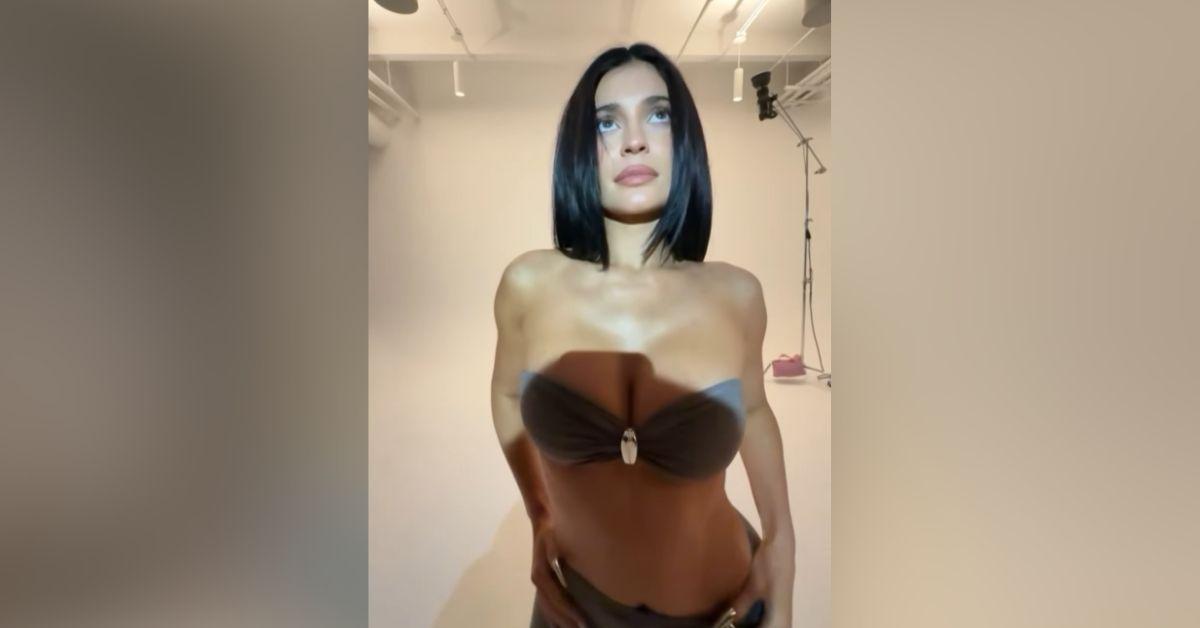 image of The reality star first appeared in a white bathrobe before changing into a gray Pierced Bandeau top and Pierced Cinch pants.