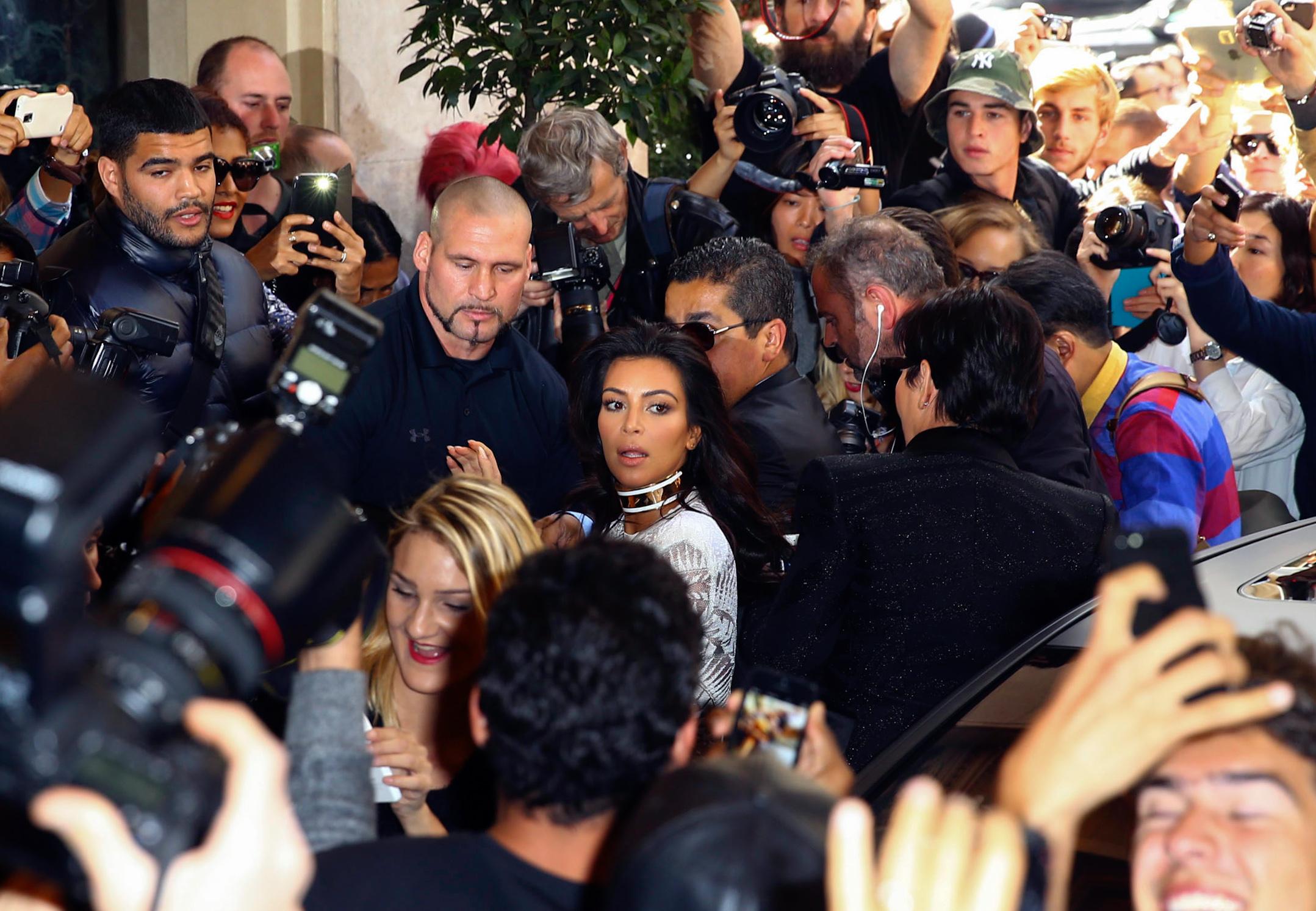 Kim Kardashian is pushed while arriving at the Balmain fashion show in Paris