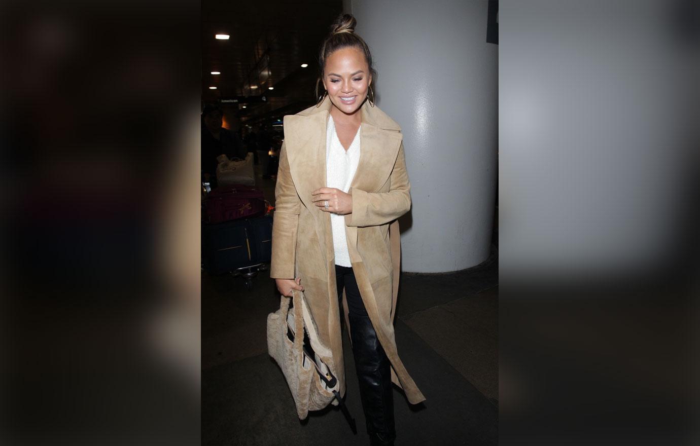 Chrissy Teigen warms up as she dashes to her flight