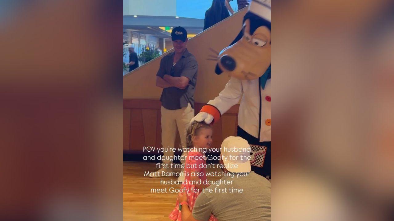 Image of Matt Damon tried to blend in the crowd as he watched the little girl's reaction to meeting Goofy for the first time.