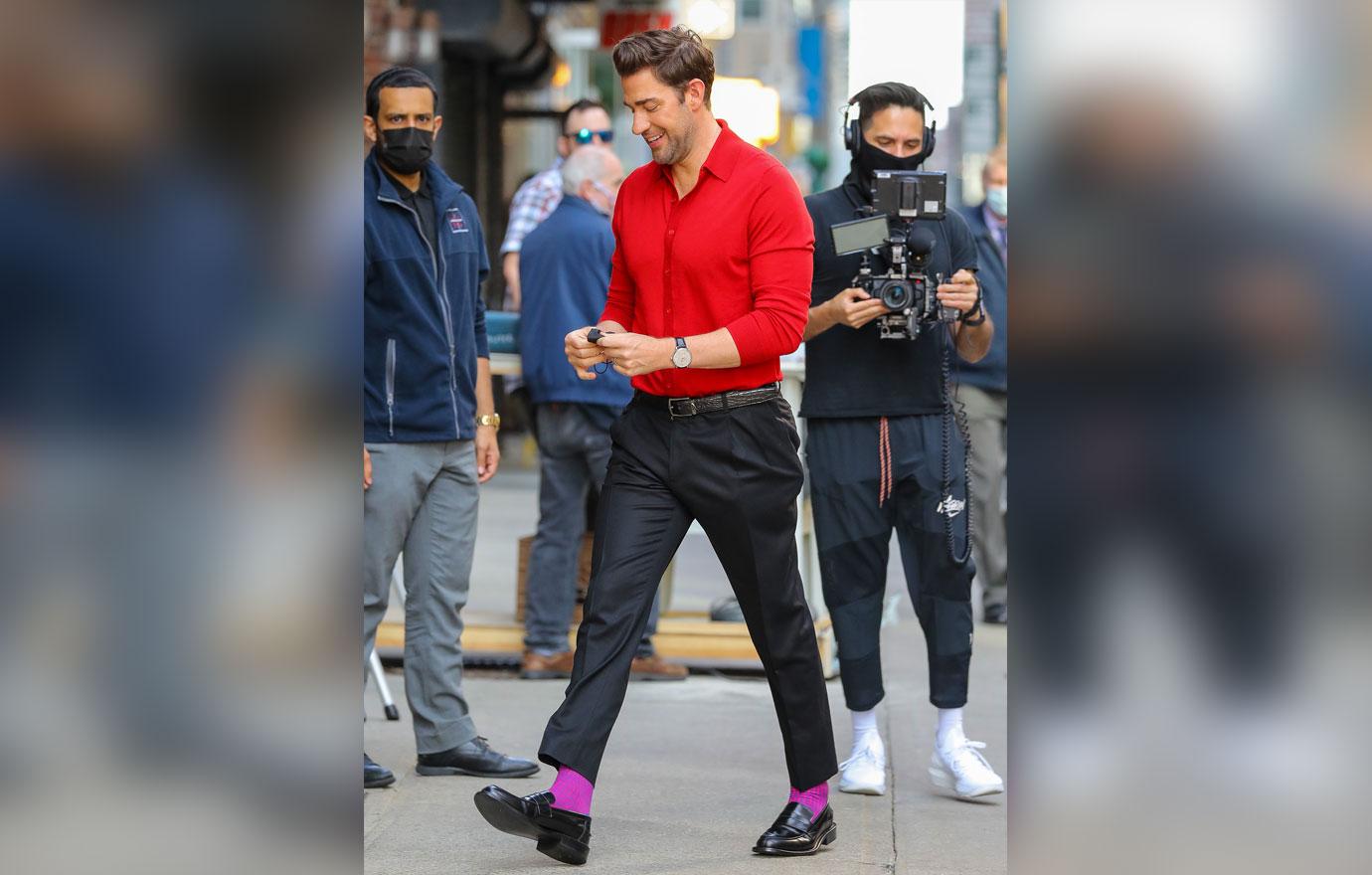 john krasinski seen wearing a red shirt and a purple socks while arrives at the late show with stephen colbert ok