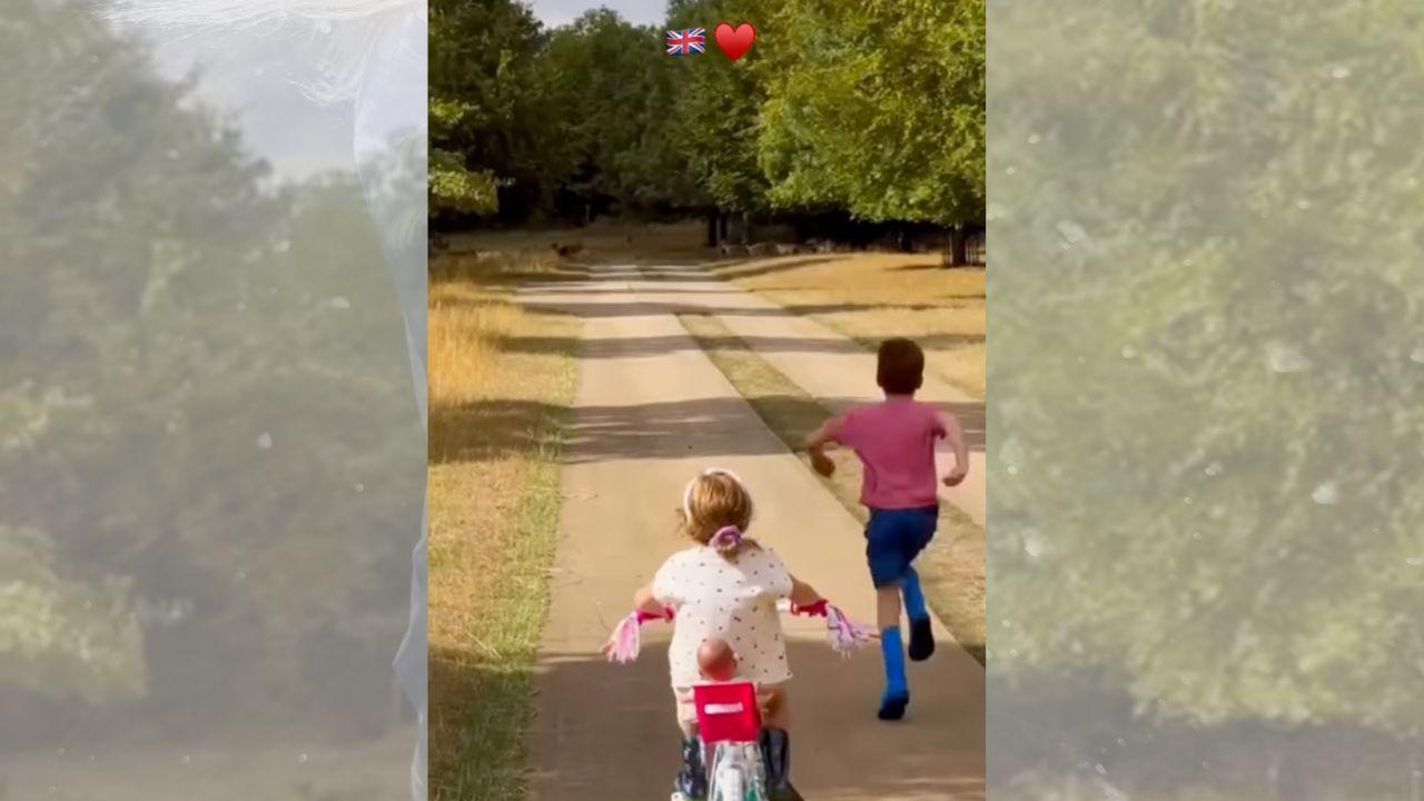 image of Prince Archie cheered on little sister Princess Lilibet as she rode her bike with a doll sitting behind her.