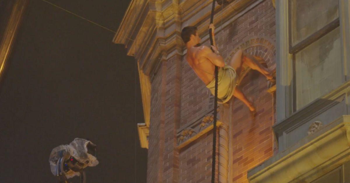 Image of Glen Powell busts through a window in 'The Running Man.'