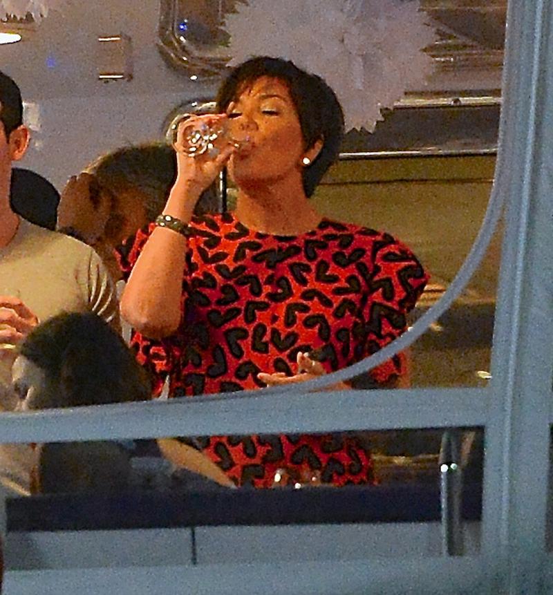 Kris Jenner talks to a young man while enjoying a drink on a yacht