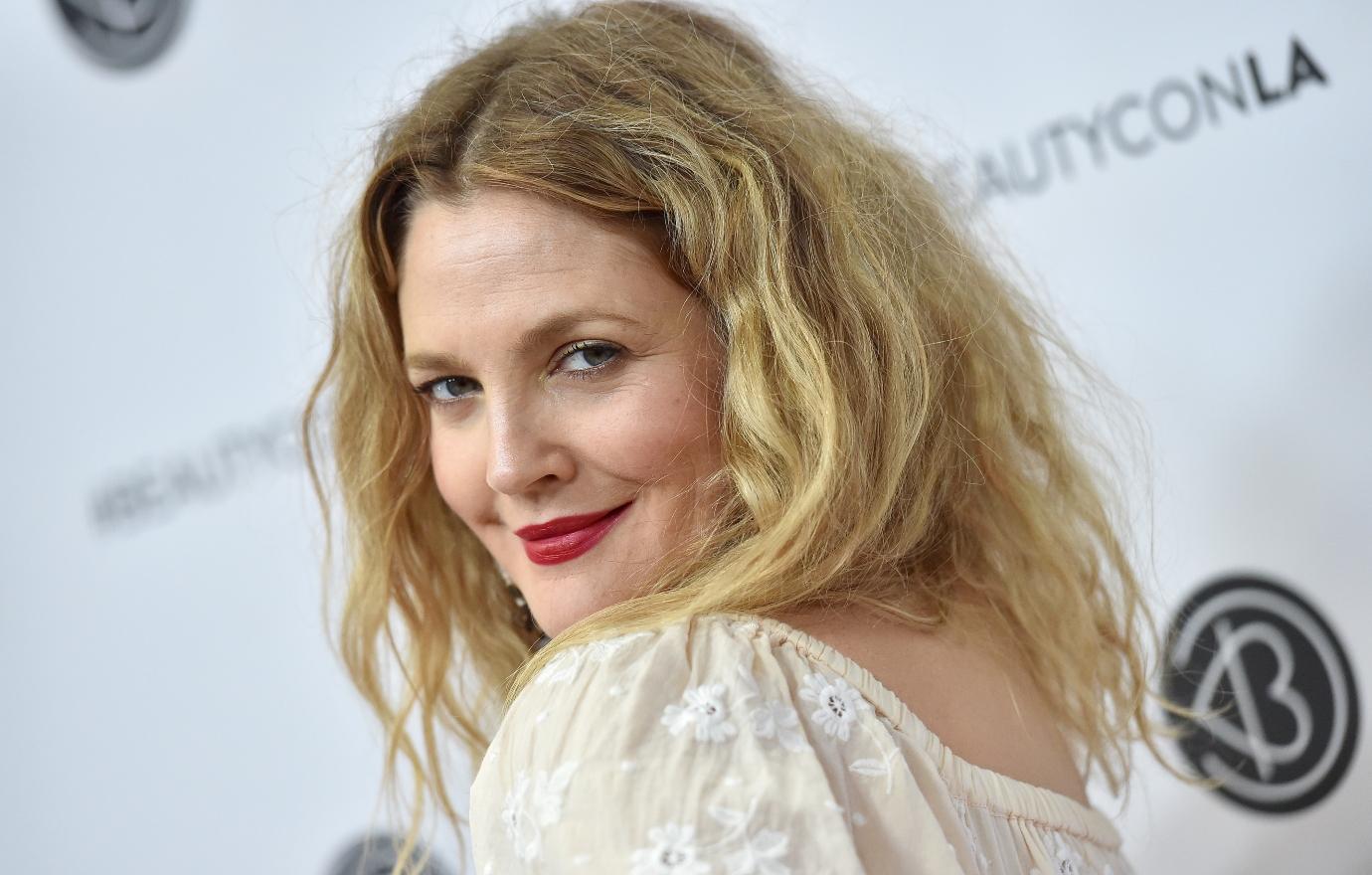 Drew Barrymore poses for the camera on a red carpet