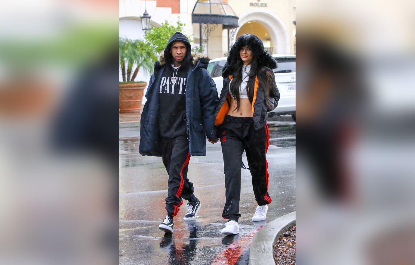 Kylie Jenner and Tyga match their Adidas pants while visiting Polacheck&#8217;s Jewelers under the rain