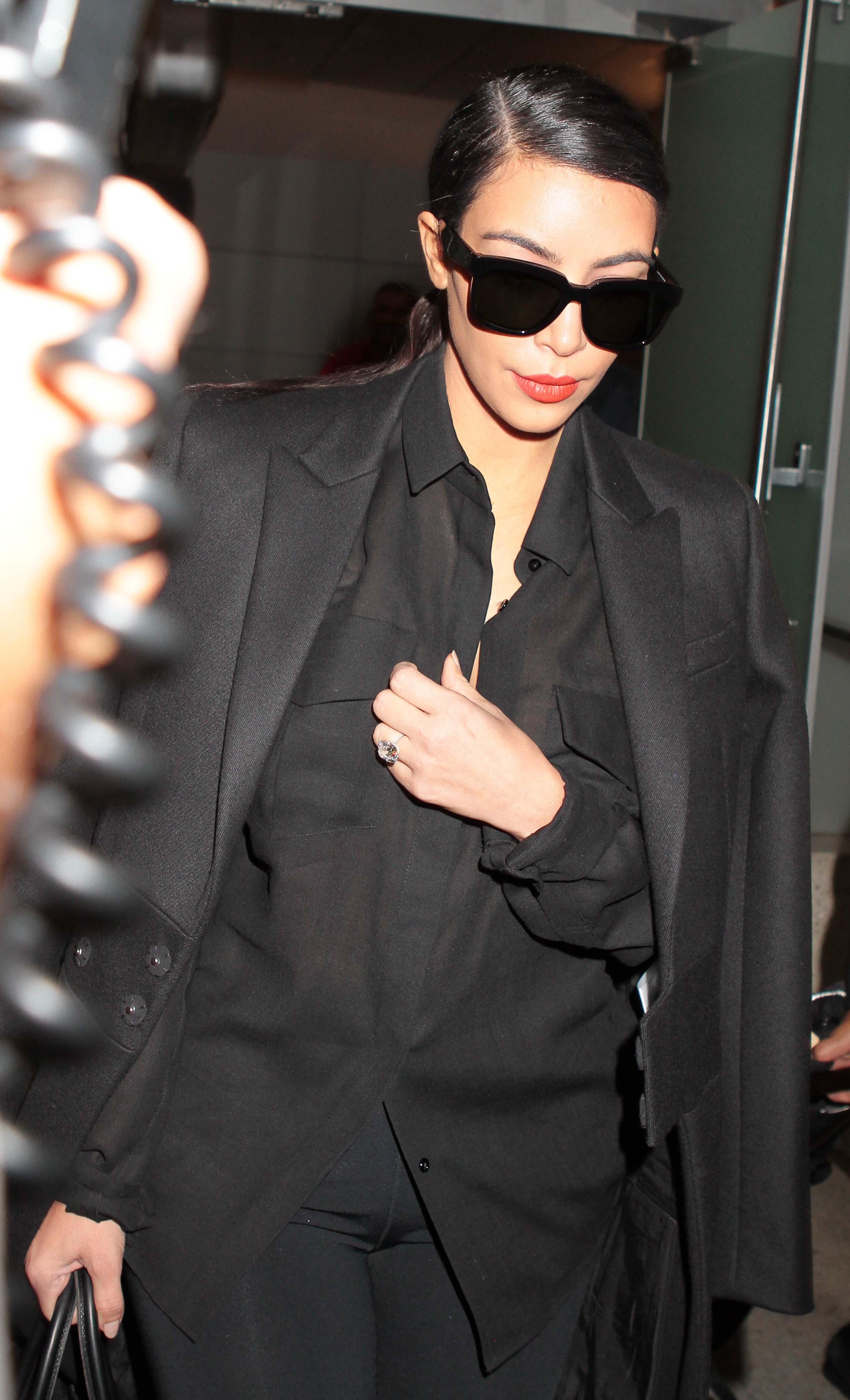 Kim Kardashian is beseiged by the paparazzi as usual as she is spotted at LAX Airport in Los Angeles, CA following her return from Dubai