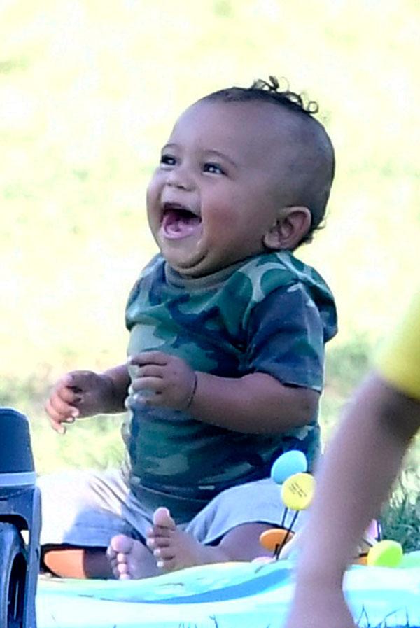 saint west smelling shoe laughing having fun in the park