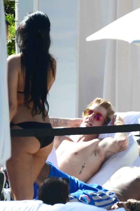 A heavily tattooed Justin Bieber kicks up his feet and relaxes poolside in Miami **USA ONLY**