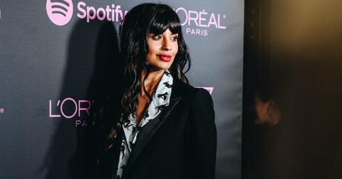 Jameela Jamil poses on the red carpet in a black jacket and patterned shirt.