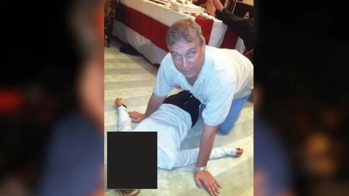 image of Newly released photos show Andrew Mountbatten-Windsor hovering over a woman lying on the floor.