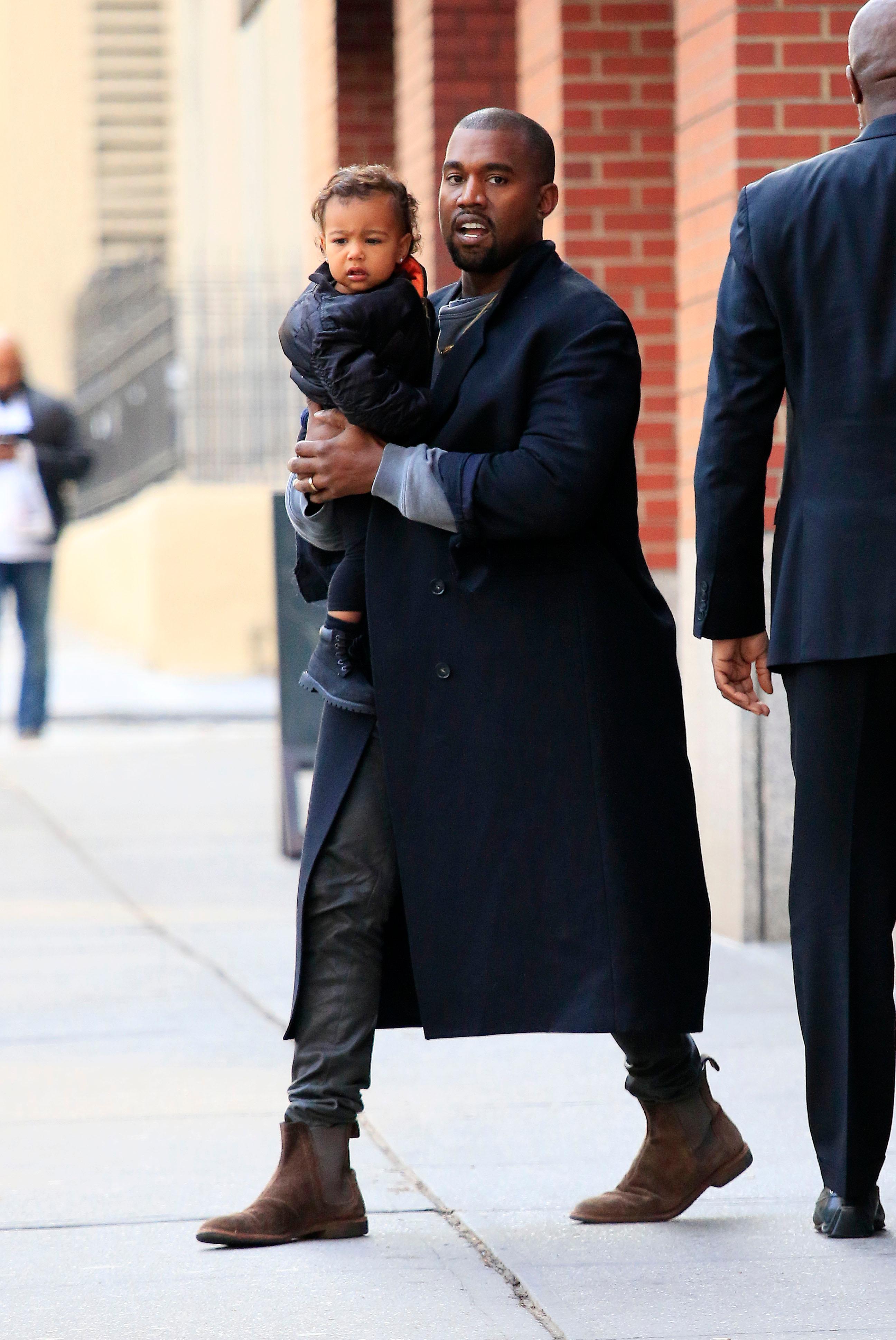 EXCLUSIVE: Kanye West carries baby daughter North West in SoHo, New York City