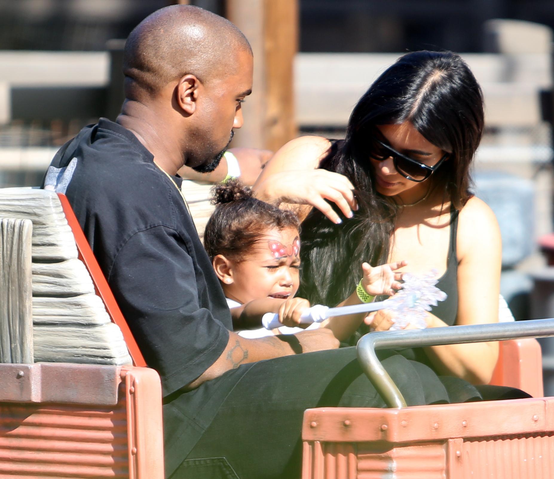 Kim Kardashian and Kanye West take yuoung daughter North on the Cars Ride as they are spotted celebrating her 2nd birthday at Disneyland in Anaheim, Ca