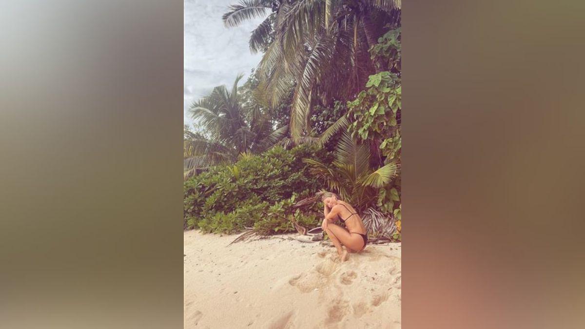 Image of Julianne Hough sun-bathed by the ocean in Fiji.