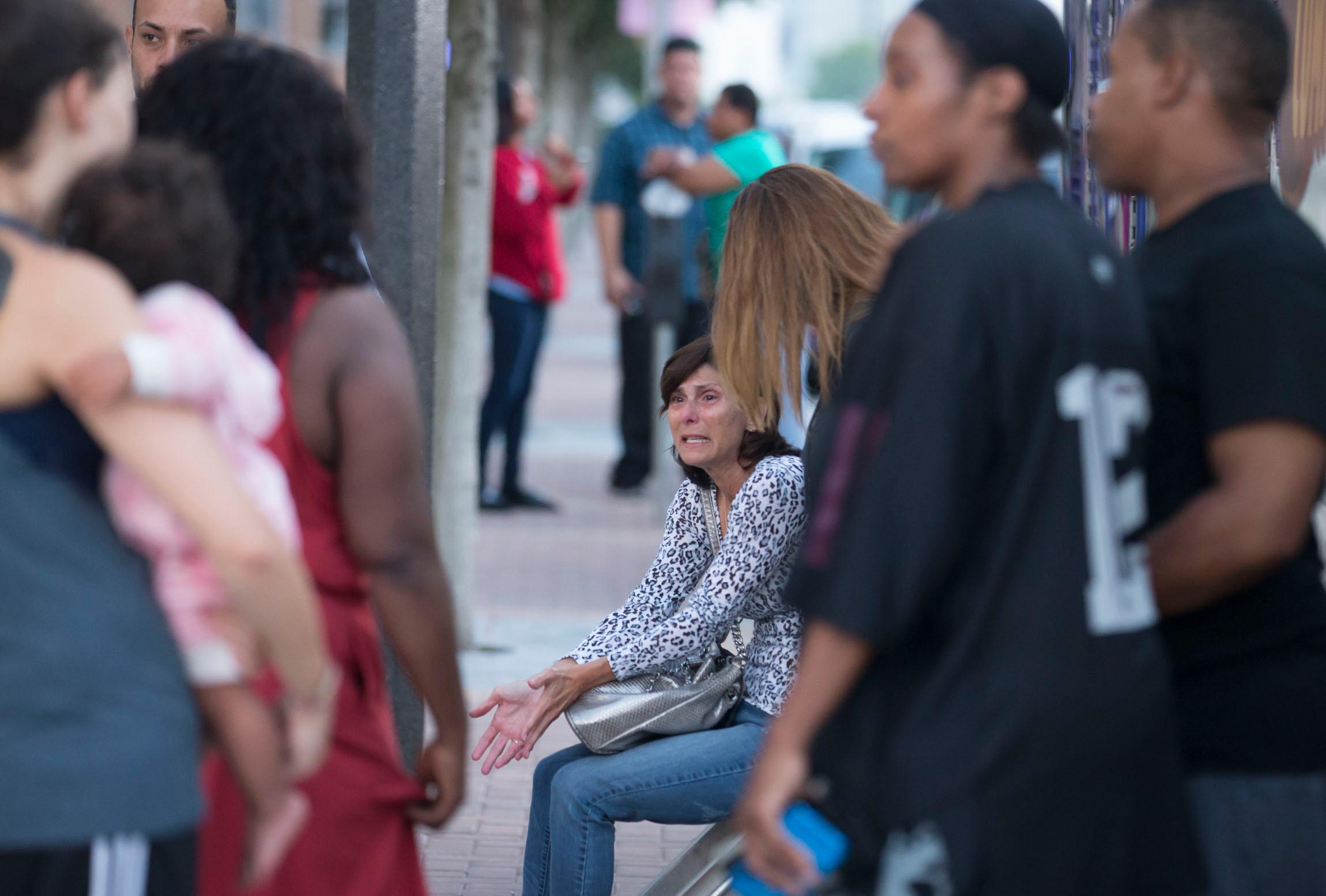 Orlando mass shooting at Pulse nightclub. Police block roads, people wait at hospital.