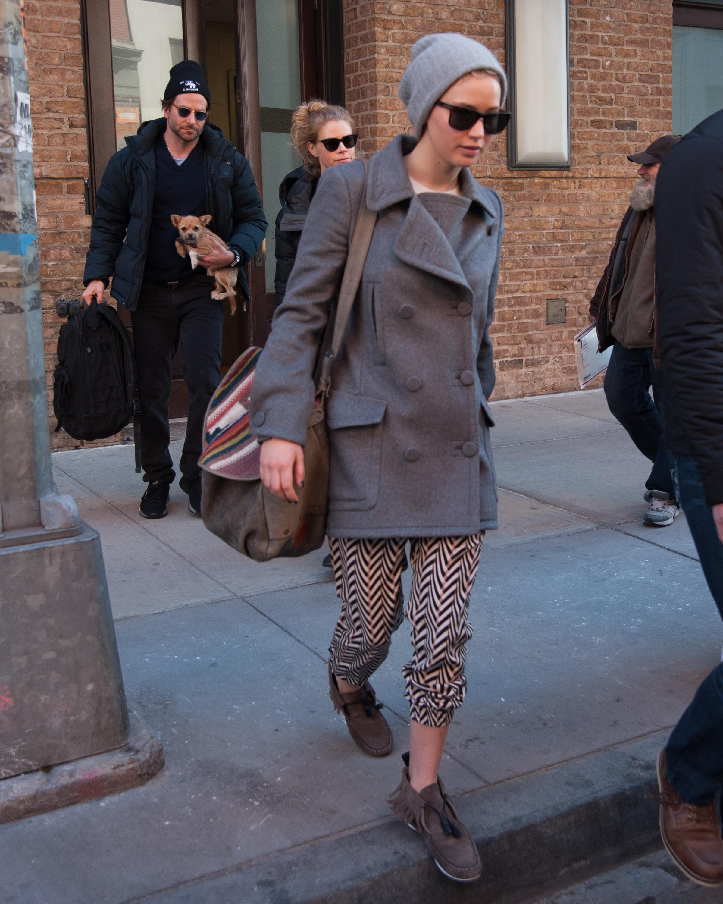 Jennifer Lawrence checks out of her hotel as Bradley Cooper holds her dog in New York City