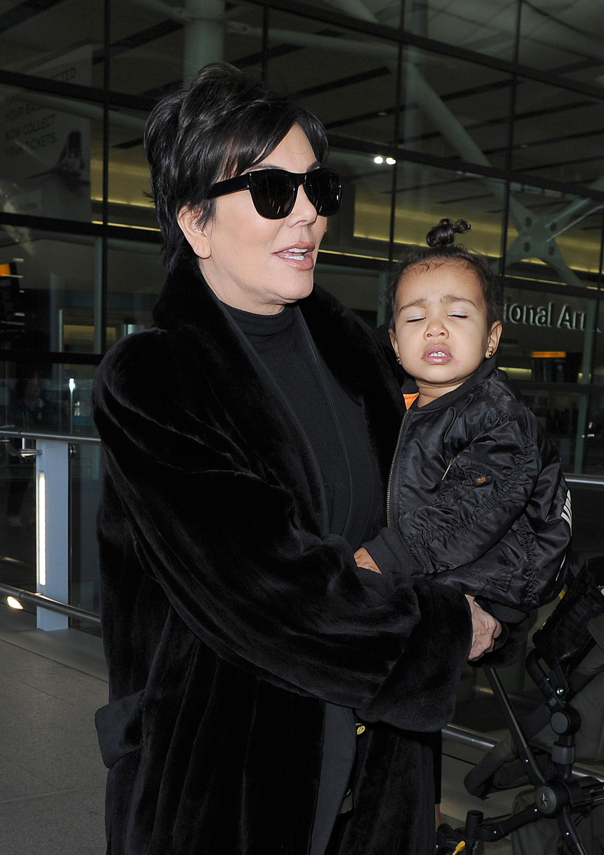 Kris Jenner arrives at Heathrow Airport, carrying baby North West, who was wearing a &#8220;Yeezus&#8221; bomber jacket to support her father Kanye