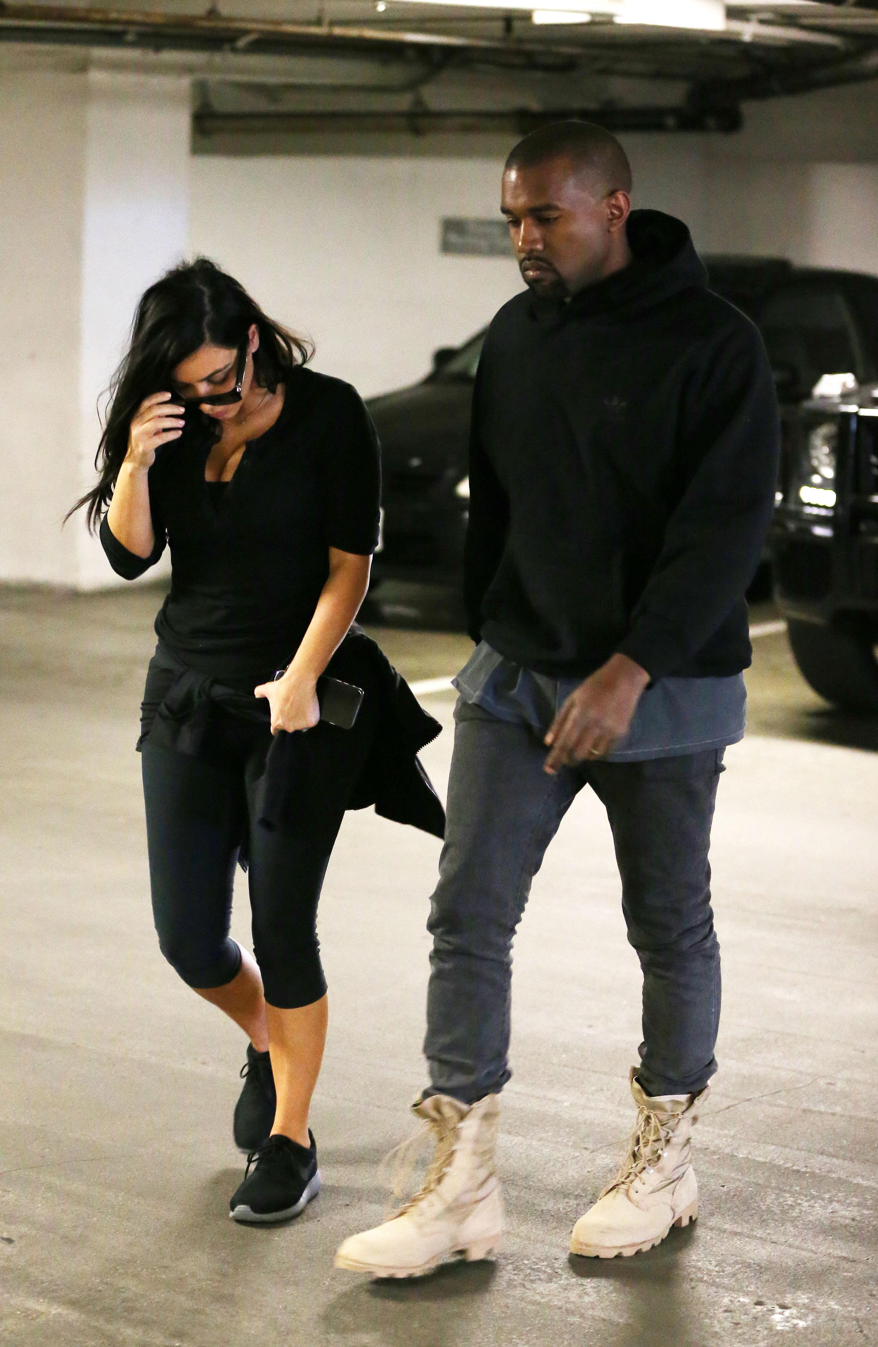 Kim Kardashian and Kanye West walking into a medical building together not looking very happy