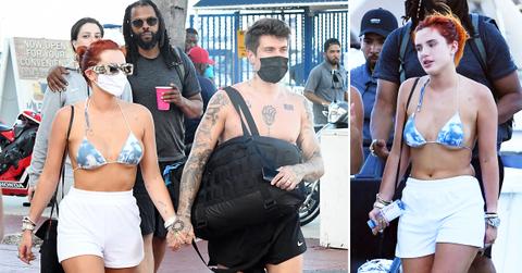 bella thorne wears a blue and white bikini as she holds hands with fiance benjamin mascolo while getting off a yacht