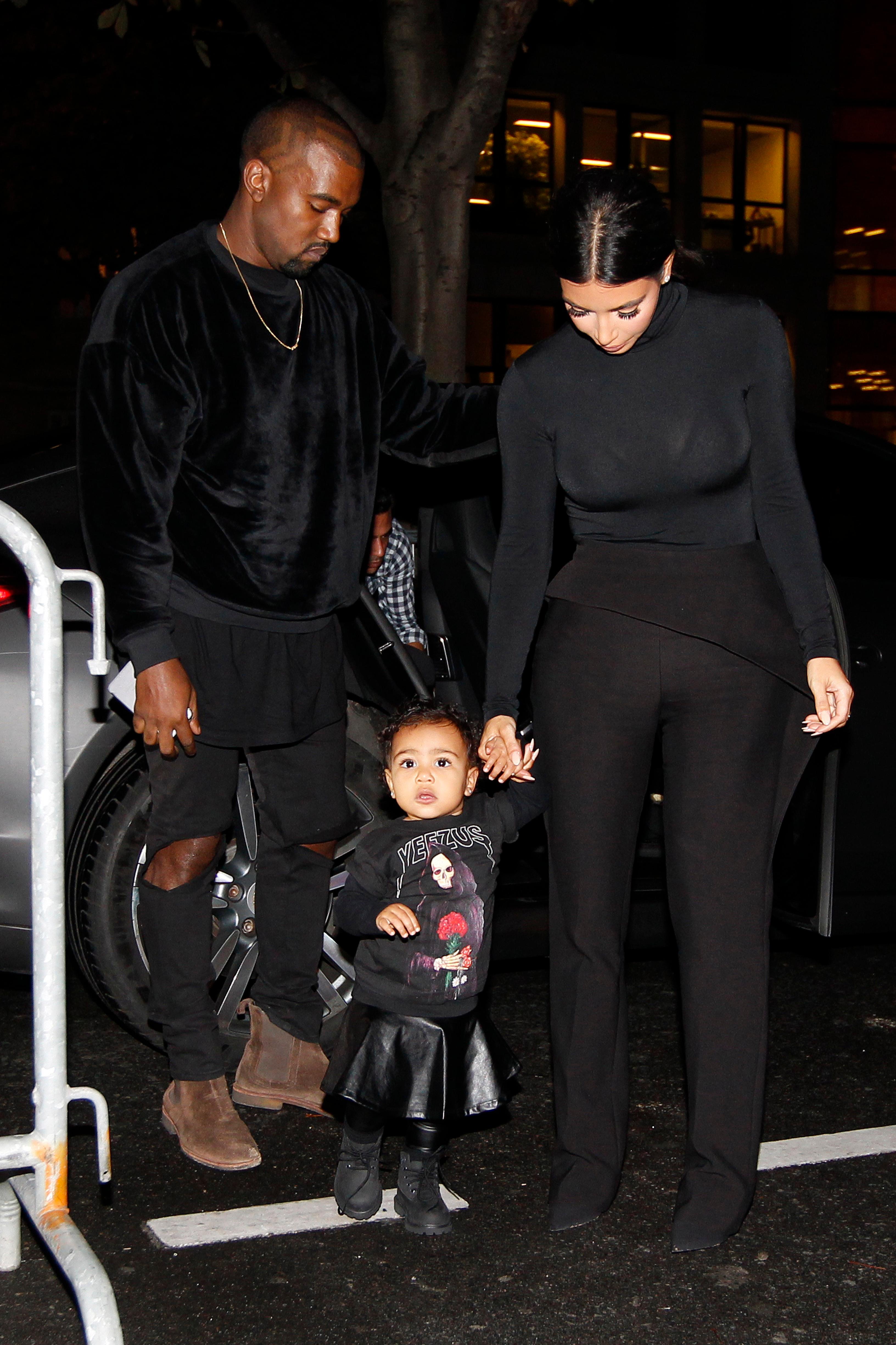 Kanye West, Kim Kardashian and their daughter North West walk to the Balenciaga Womenswear Spring/Summer 2015