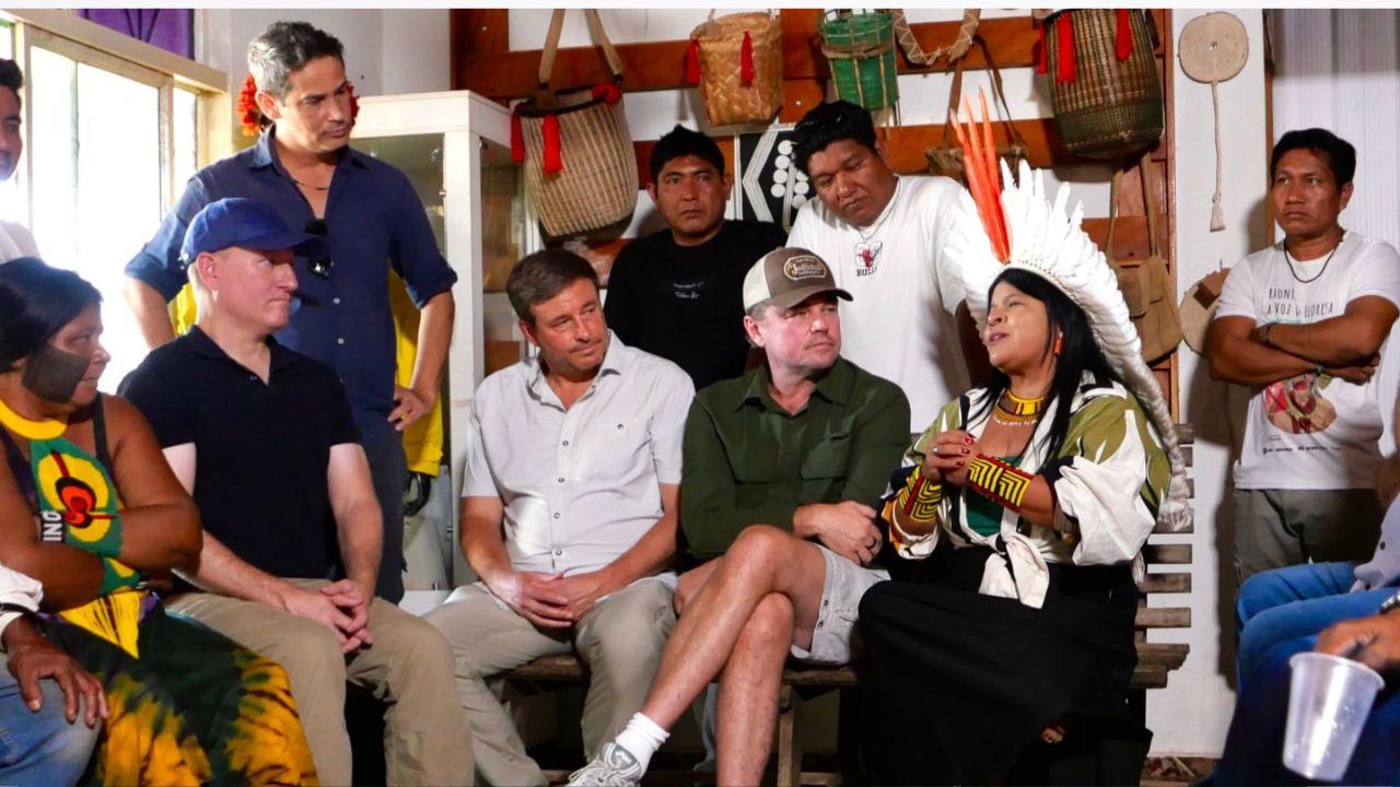 Image of Leonardo DiCaprio with other environmental conservationists listening to Indigenous leader Sônia Guajajara.