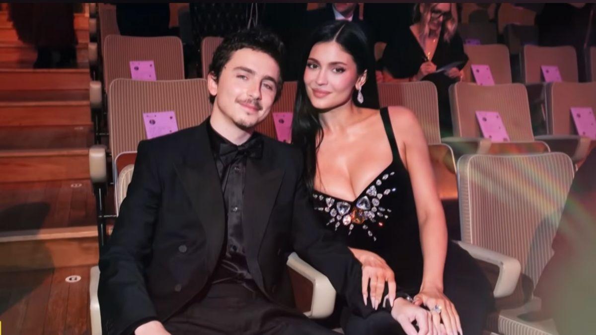 Image of Kylie Jenner sat alongside partner Timothée Chalamet inside the event venue.