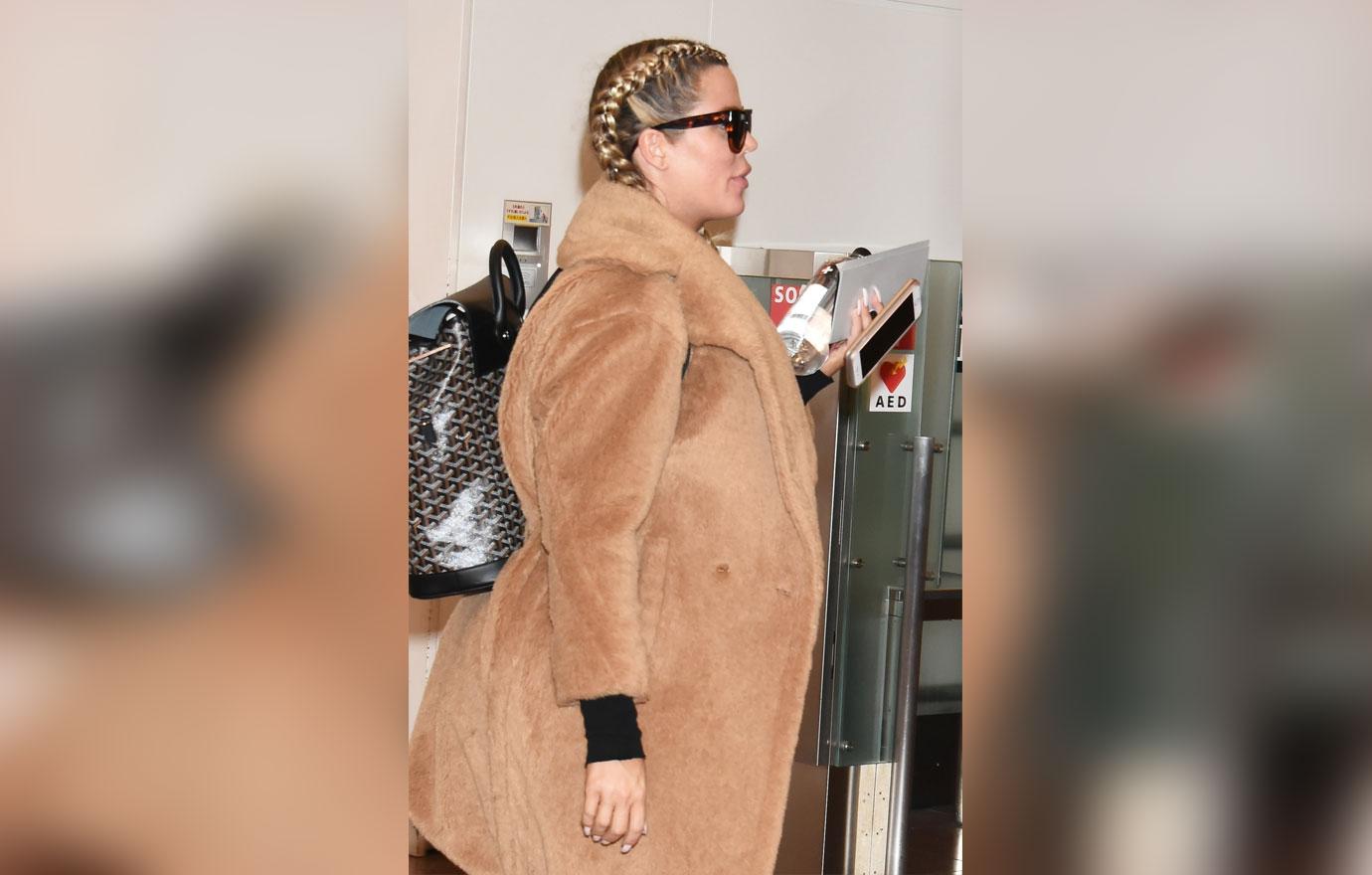 Khloe kardashian cradles baby bump