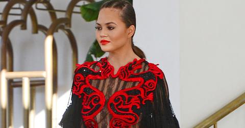 *EXCLUSIVE* Chrissy Teigen stuns in and red and black gown for a friend’s wedding