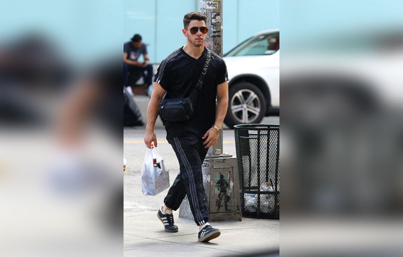 First photos of Nick Jonas carrying a 6 pack of beers after engagement news last week in NYC