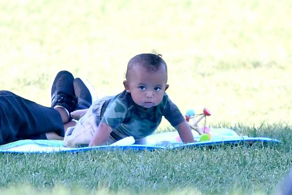 saint west smelling shoe laughing having fun in the park