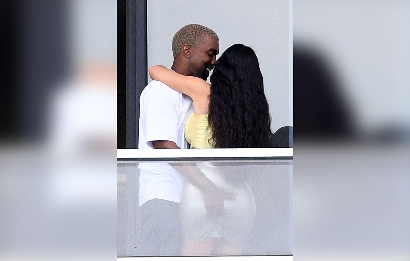 Kim and Kanye share a passionate kiss on the balcony of their new Miami pad