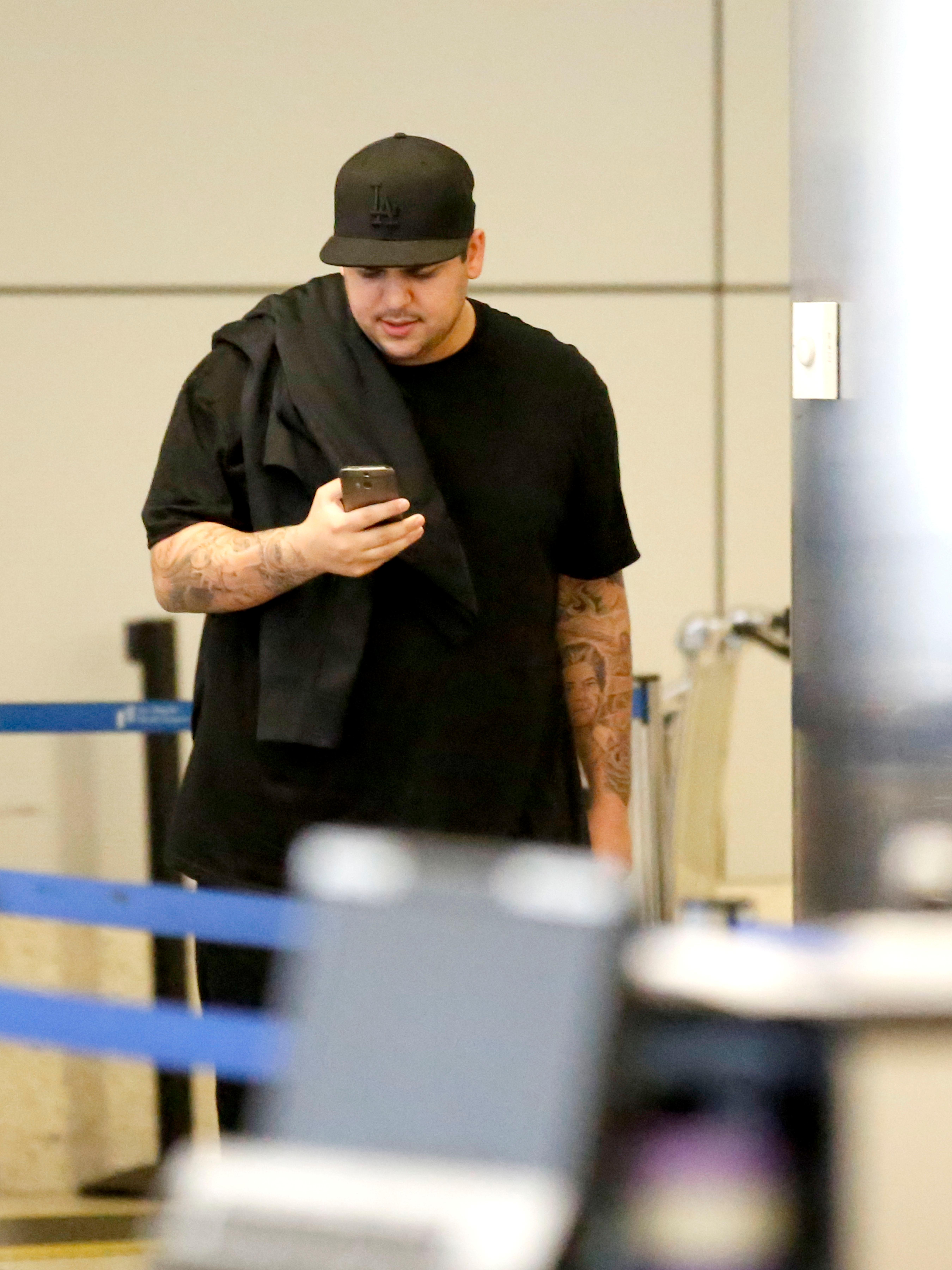 Rob Kardashian skips his sister&#8217;s wedding amidst reports there was a family clash as he is seen at LAX on the same day Kim Kardashian is due to get married to Kanye West at the Palace of Versailles