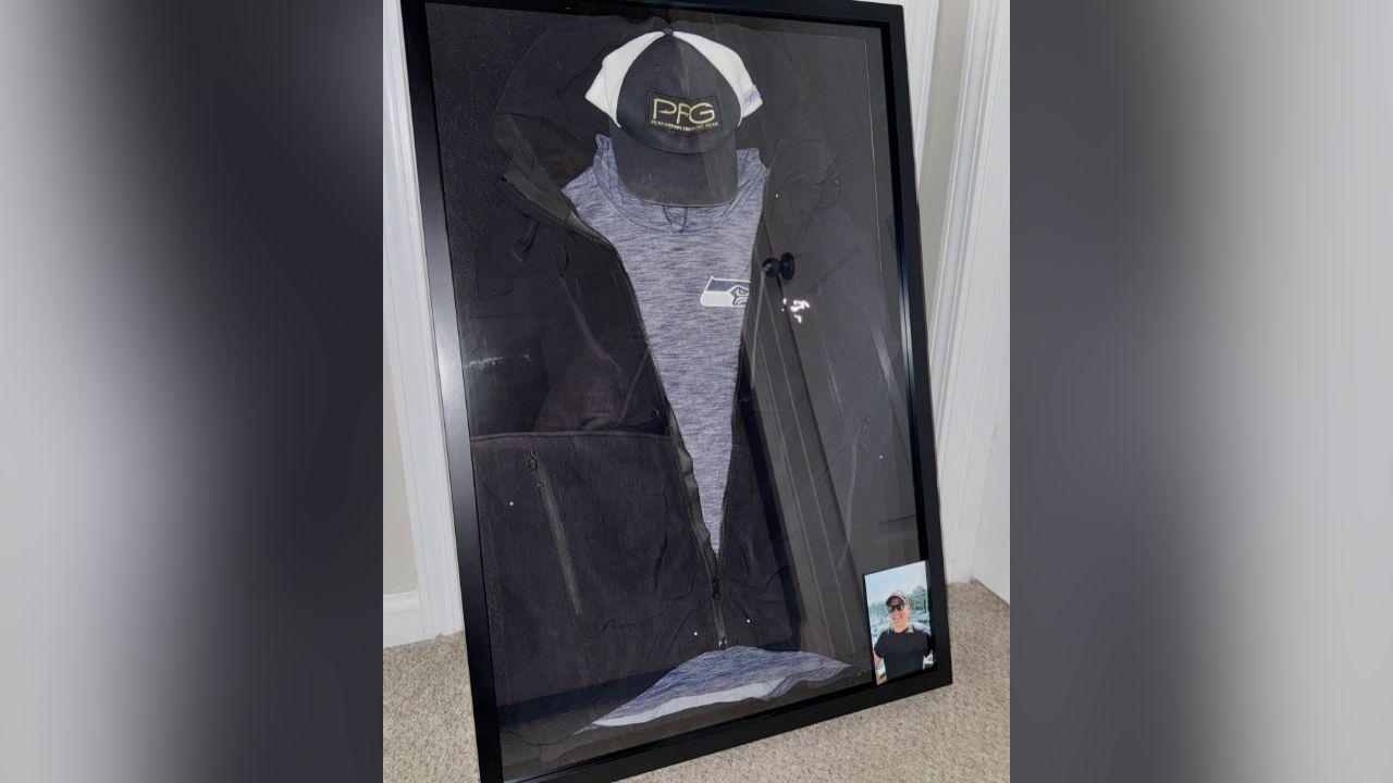 Image of Ken Urker's Seahawks hoodie, favorite jacket and baseball cap were preserved in a shadow box.