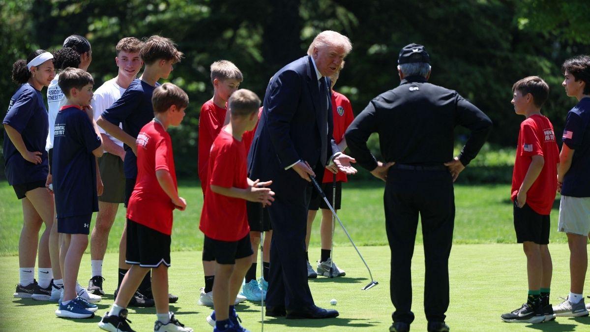 Photo of Donald Trump attempted to putt the ball twice before handing the golf club over to a nearby colleague. 