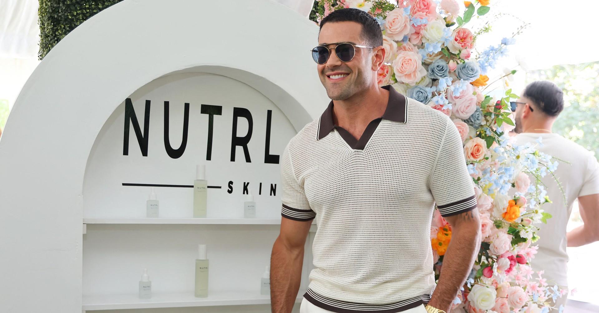 Photo of Jesse Metcalfe holding his product at Jill Zarin's Luxury Luncheon. 