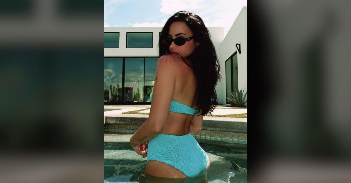 Image of Demi Lovato stripped down to a bright blue bathing suit.